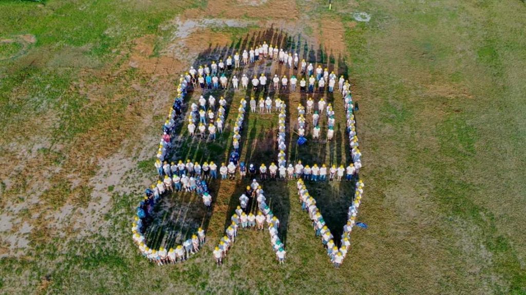 About 250 volunteers stood to form the shape of a house and letter CAV - Care-A-Vanners.