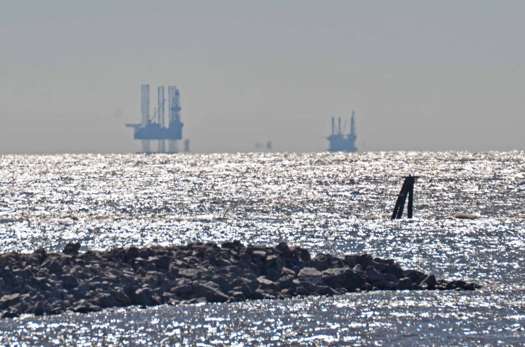 Offshore platforms that support the submerged oil and gas wells in the Gulf of Mexico visible from the Louisiana coastline.