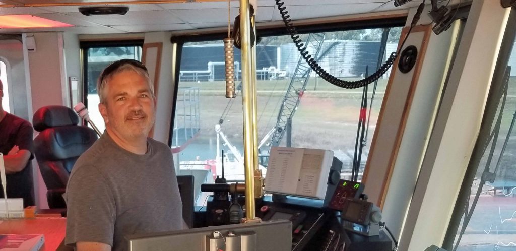 Brad Saum at the helm with the  Captain's view from the William James tug boat while docked in the Yazoo River.