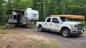 RV camper and truck parked at campsite at McLain State Park on Lake Superior in Michigan's Upper Peninsula.