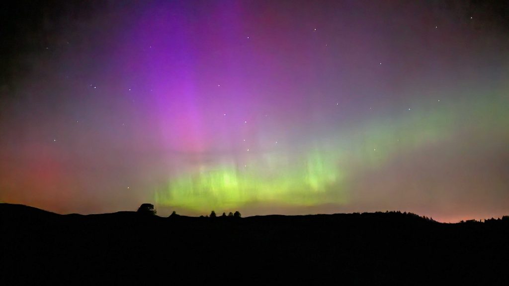 Purple and green light the night sky produced by the northern lights.