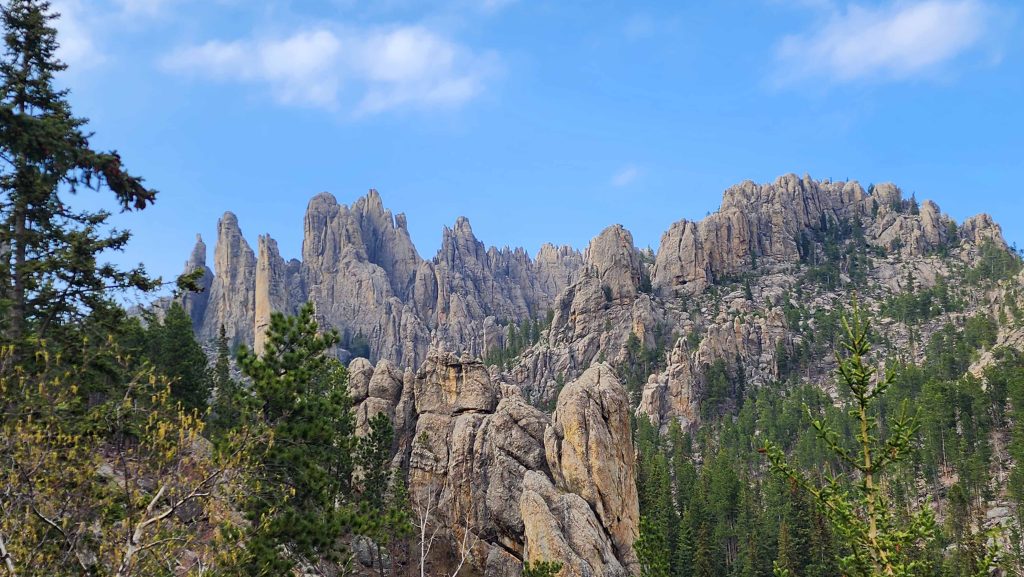 Natural rock formation of granite called the Cathedral Spires against a blue sky.