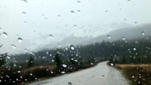 rain on windshield with blurred view of mountains