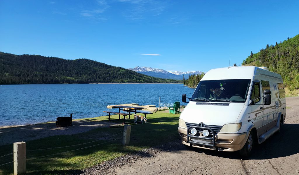 Van parked near Grande Cache Lake with mountains in background.
