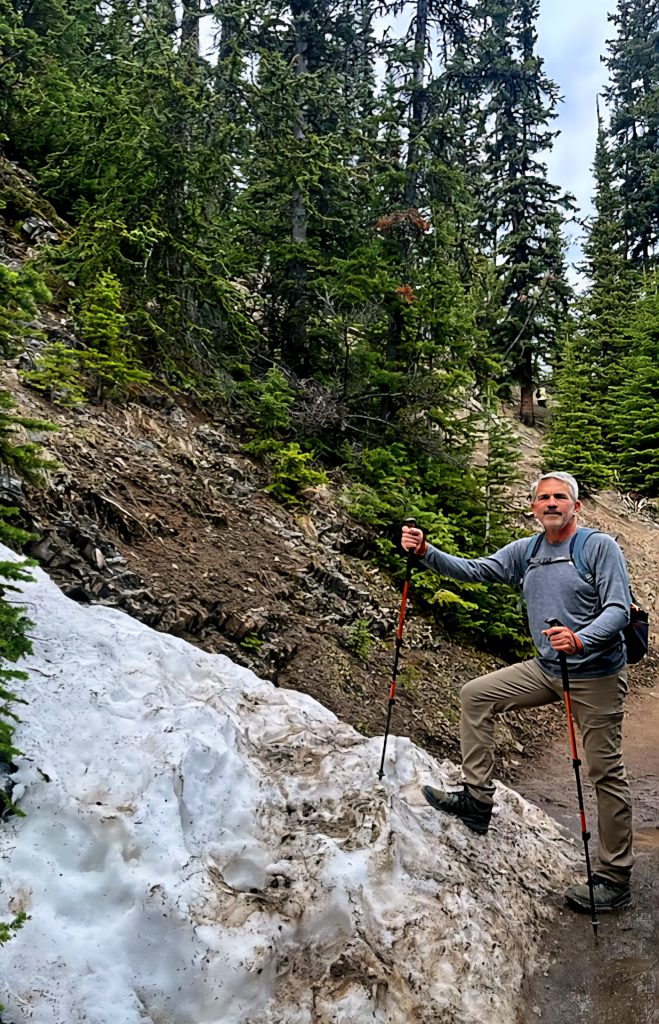 Brad Saum Hiking trail in Banff National Park holding hiking poles in the snow