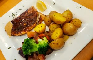 plate containing cooked Arctic Char, potatoes and vegetables