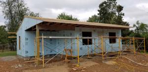 We installed the fascia board along the lower edge to the roof trusses and the blue foam insulation was added to the exterior of the house.